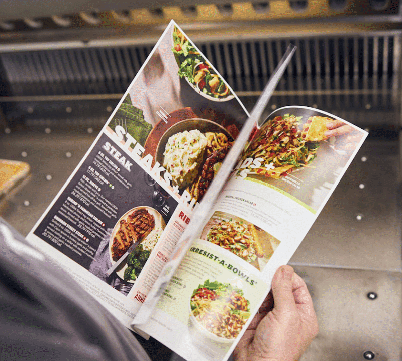 person flipping through restaurant menu