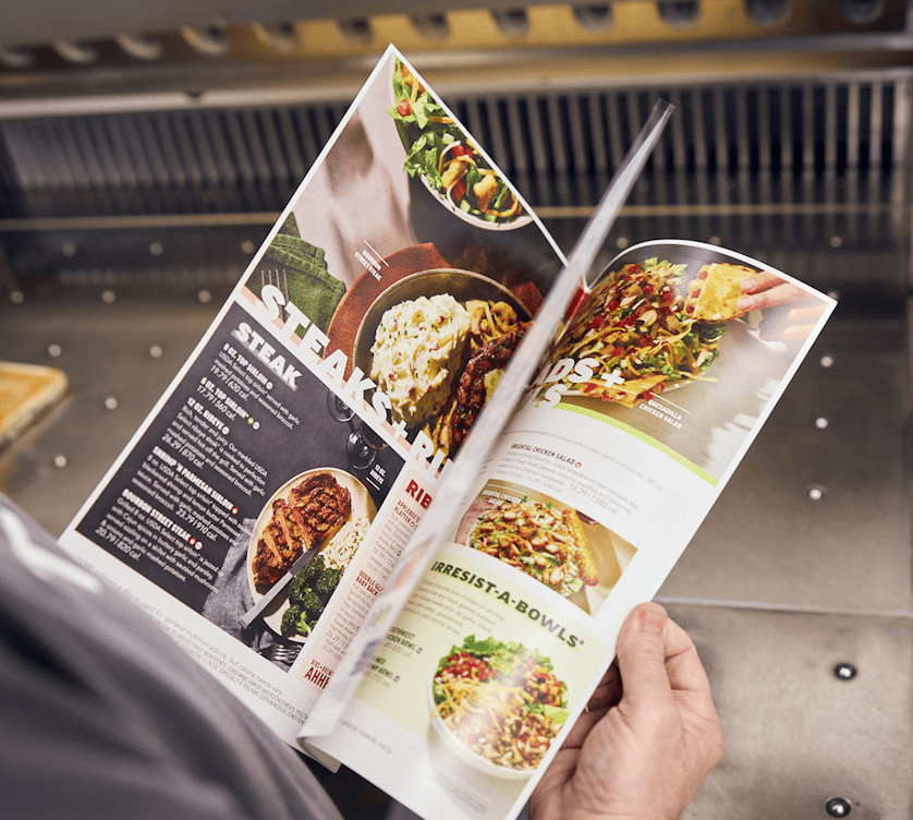 person flipping through restaurant menu